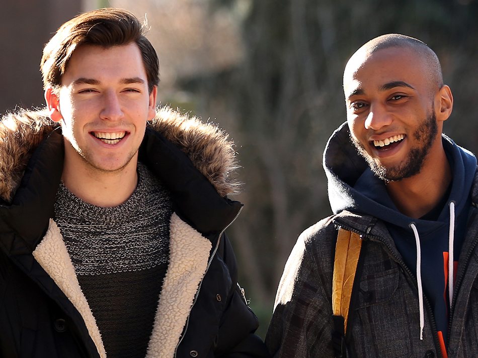 two students smiling in heavy coats